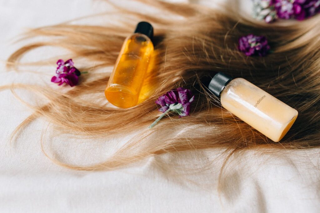 pexels-photo-8467963 Hair care products on a bed of hair and flowers, symbolizing luxury and beauty.