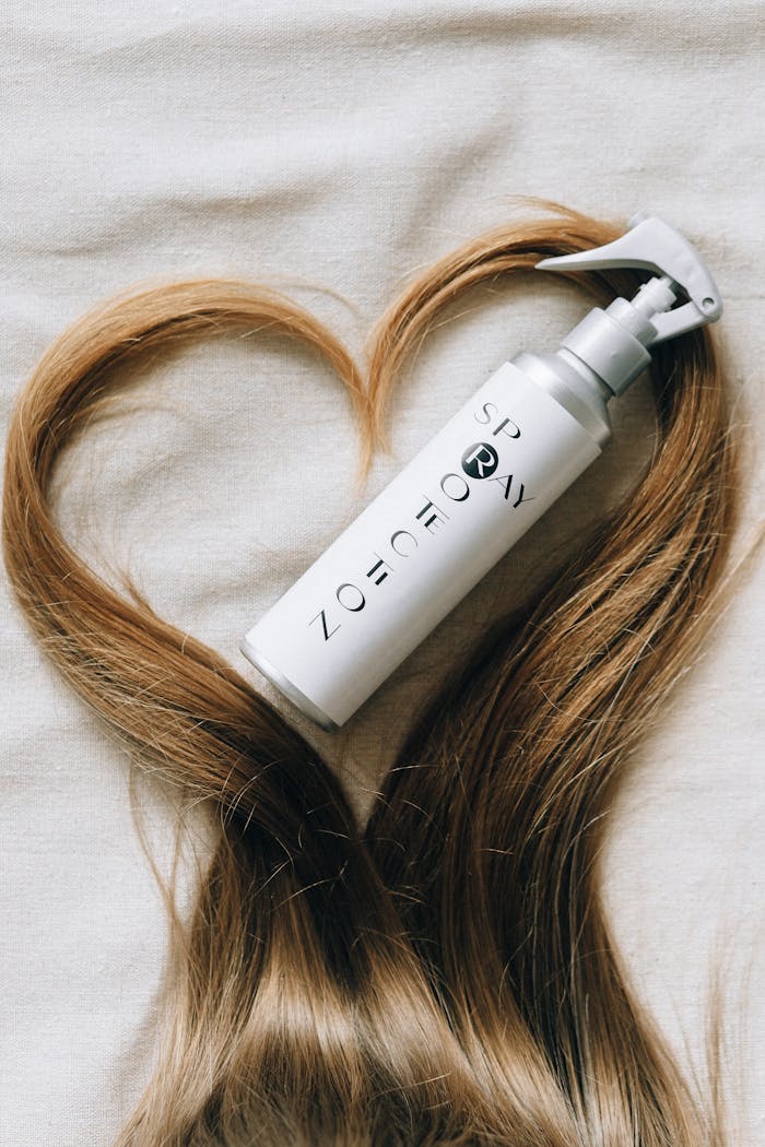 about-us-02 Hair product bottle surrounded by hair in heart shape on fabric, showcasing elegant hair care.